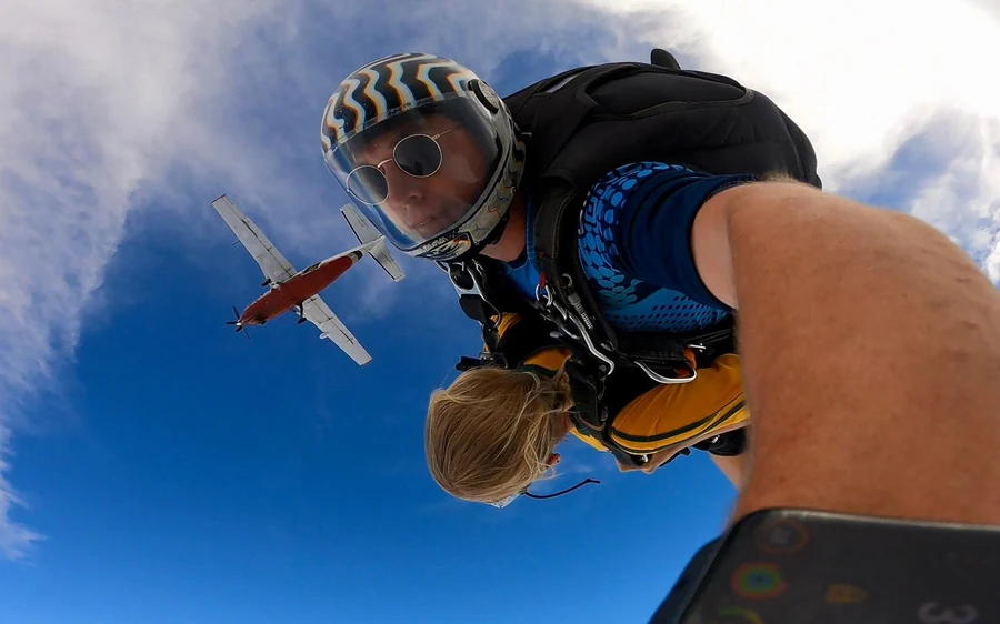 A tandem pair just after the exit, with the aircraft they jumped from still in the sky behind them